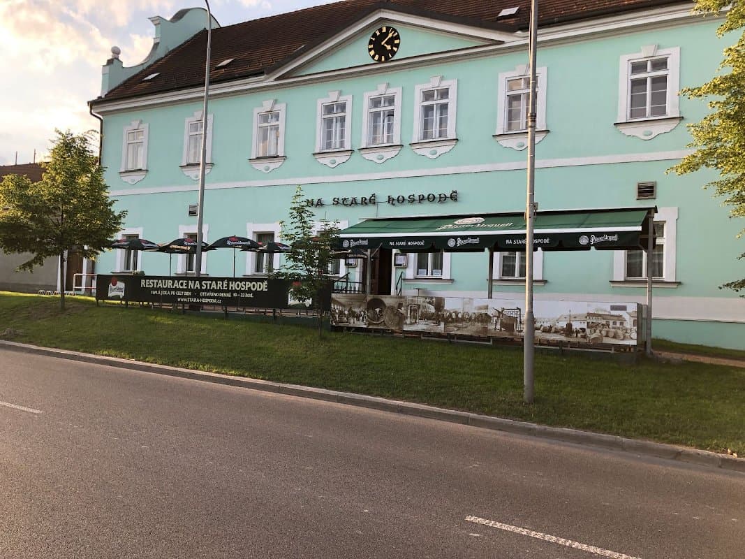 Historická zelená budova restaurace Na staré hospodě v Hloubětíně